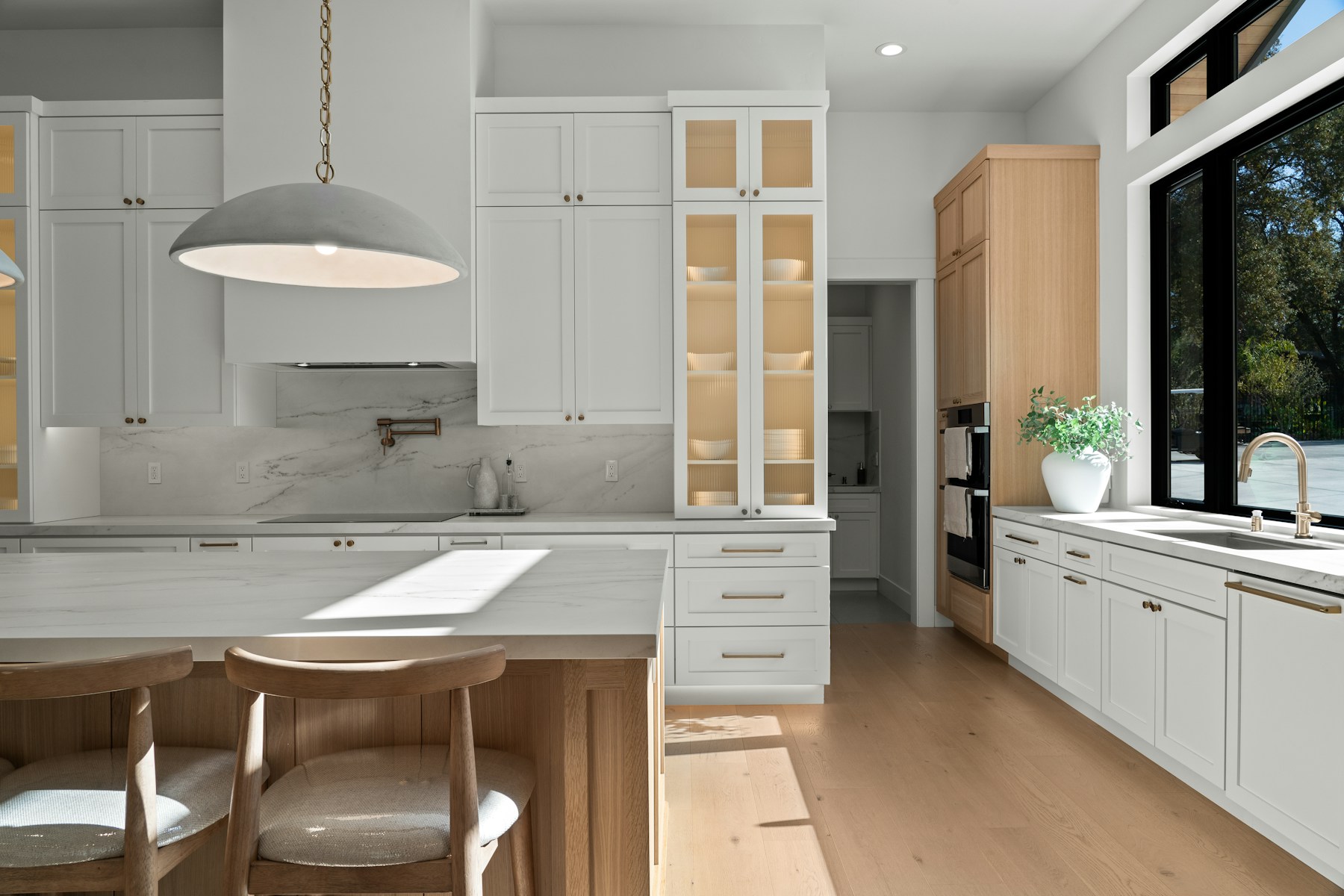Illustrative bright kitchen with white cabinetry, timber details and a large island